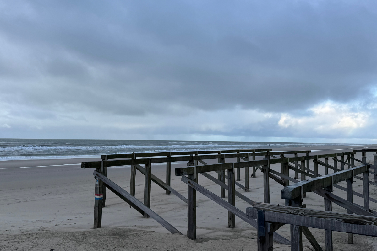 Donker lucht op het strand met palen en woeste winterzee